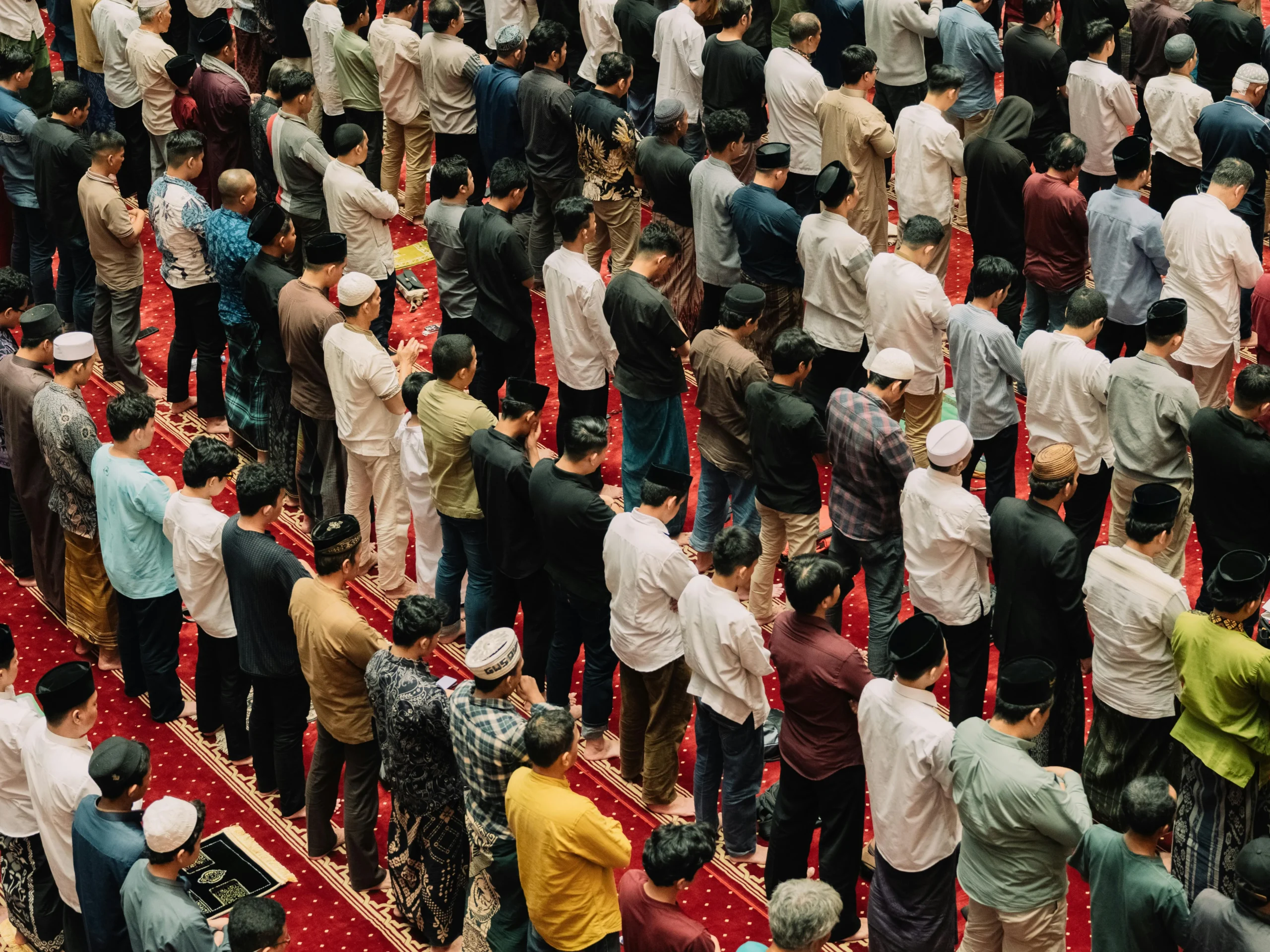 pexels-apyfz-30947036 A large group of people gathered inside a mosque, engaged in prayer and reflection.