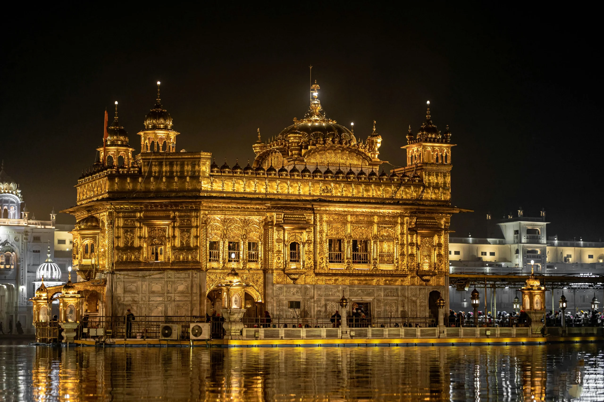 Golden Temple The Golden Temple is majestically lit at night, reflecting on tranquil water. It exudes serenity and architectural splendor under a dark sky.
