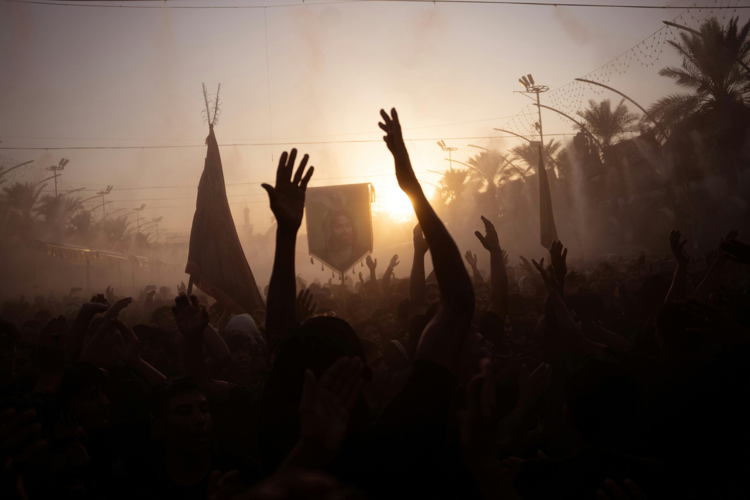 ashura A crowd of people throws colorful powder into the air during an outdoor Holi festival, filling the scene with vibrant clouds of color.