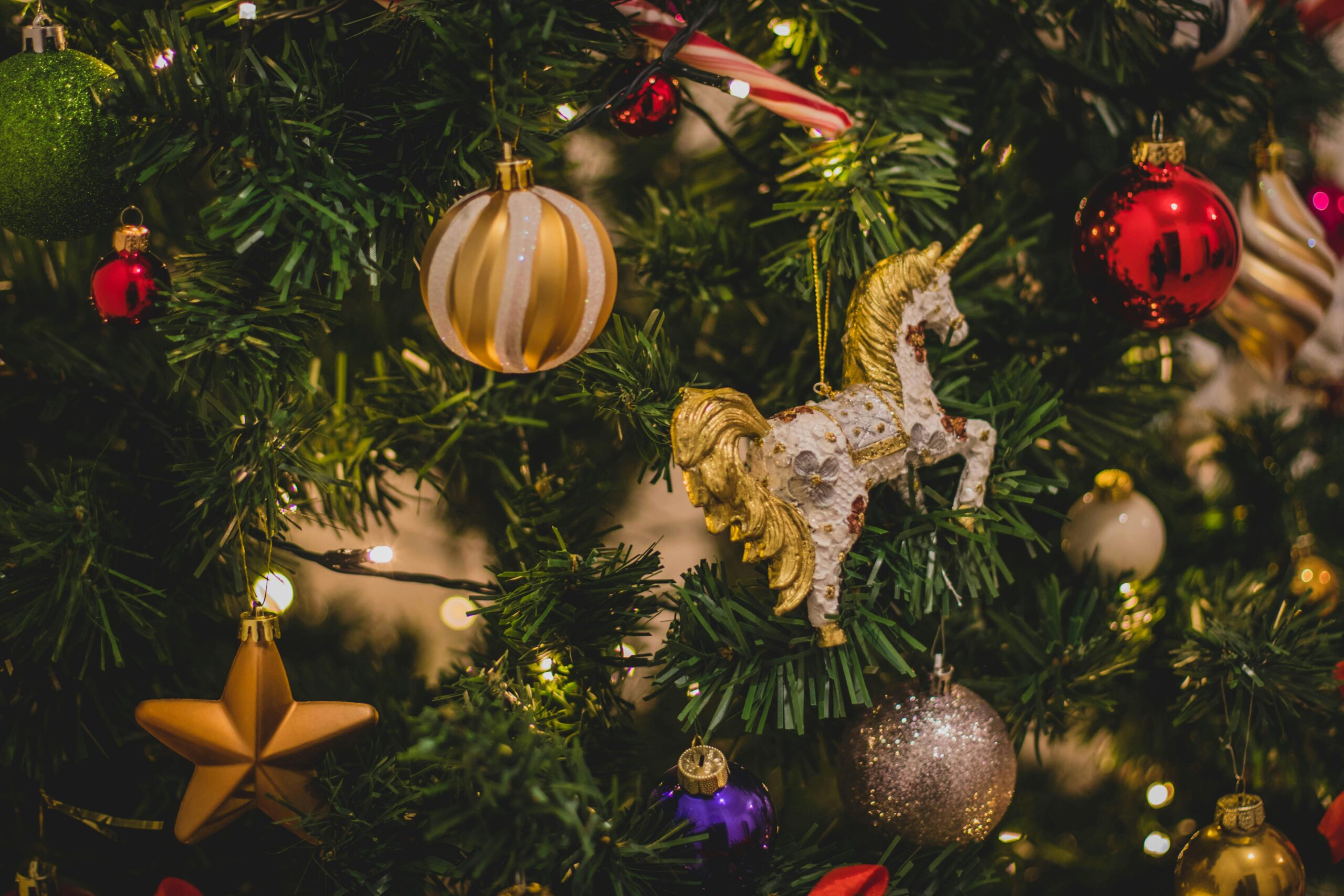 Christmas Tree With stars and horse A festive Christmas tree featuring bright ornaments and a playful unicorn nestled among the branches