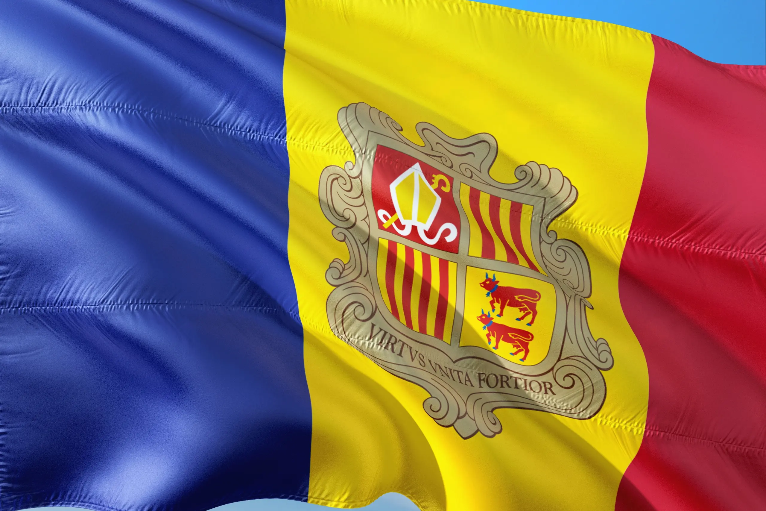 Flag of Andorra featuring blue, yellow, and red vertical stripes with the national coat of arms in the center