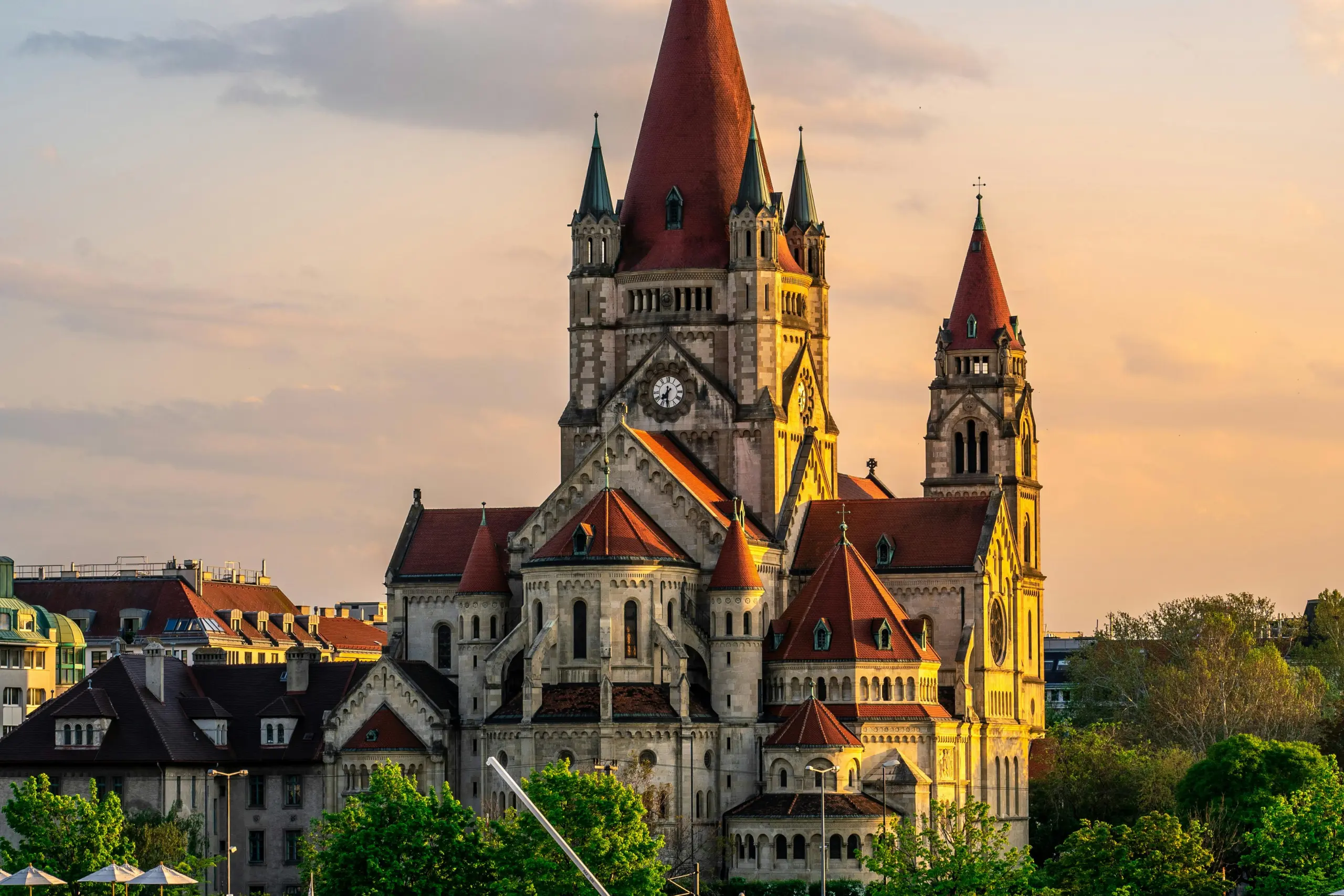 A panoramic view of an Austrian city with historic buildings and church towers under a clear blue sky.