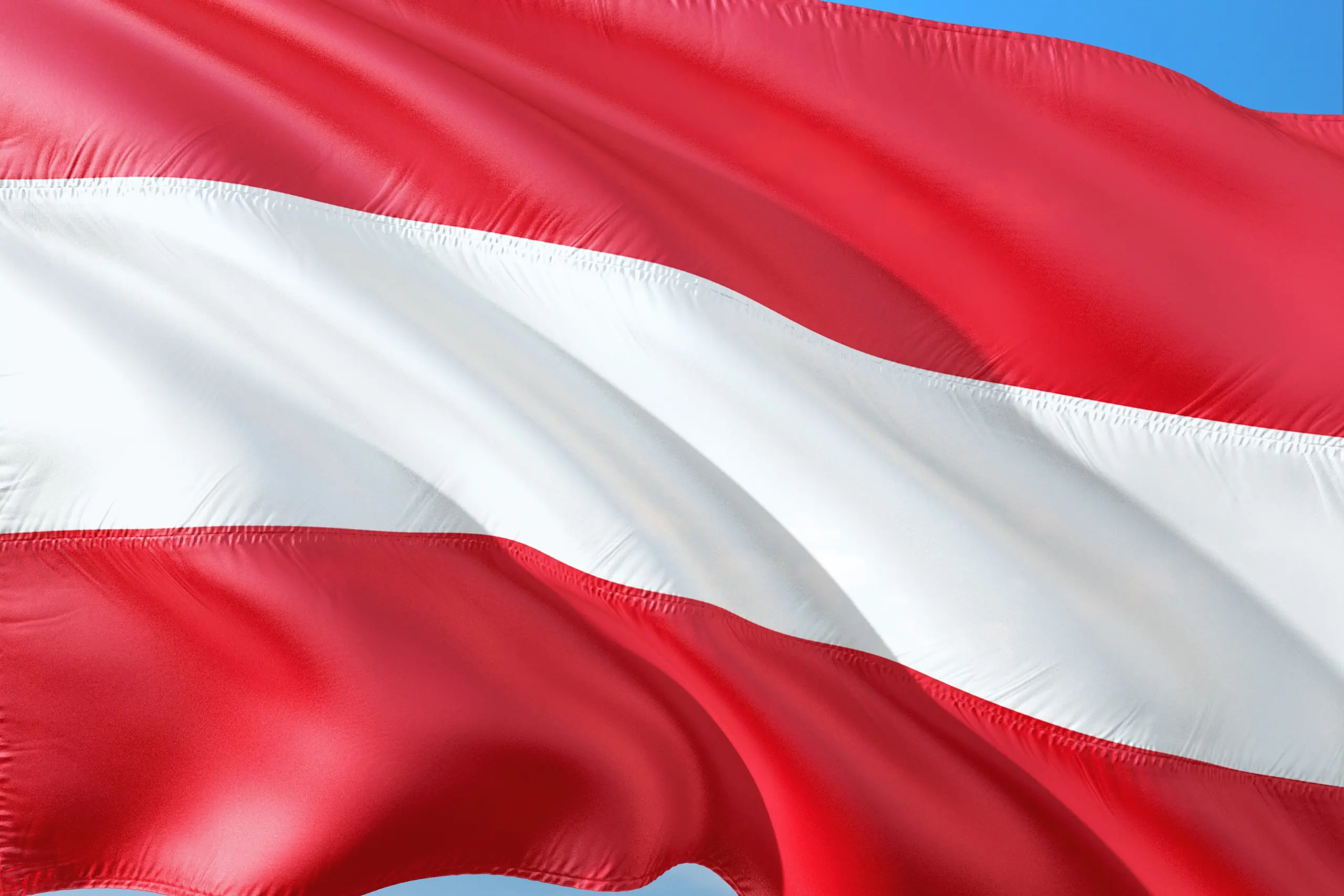 Austria national flag with red and white stripes waving in the wind