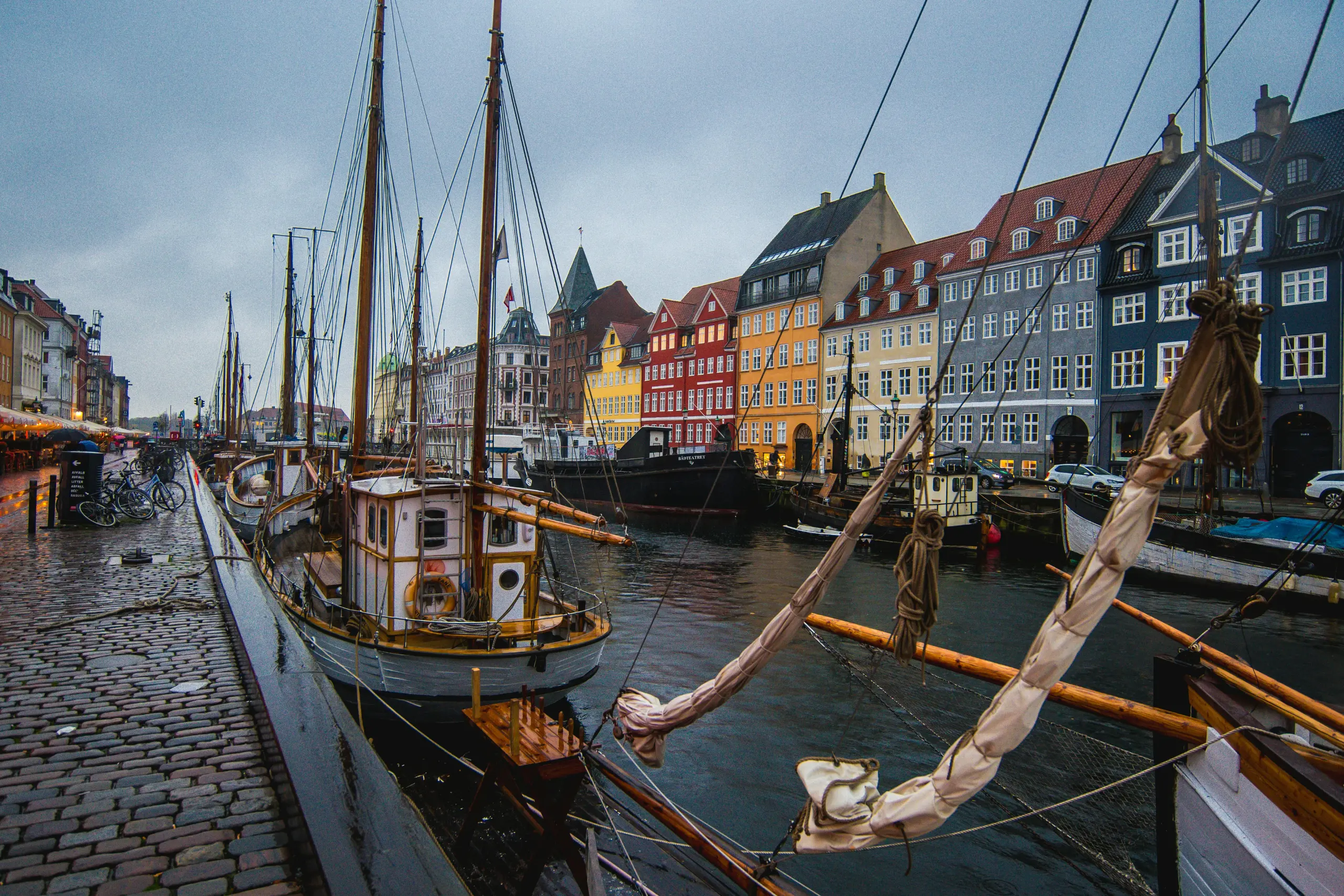 A scenic view of a Danish city showing a bridge, waterfront houses, and calm blue water.