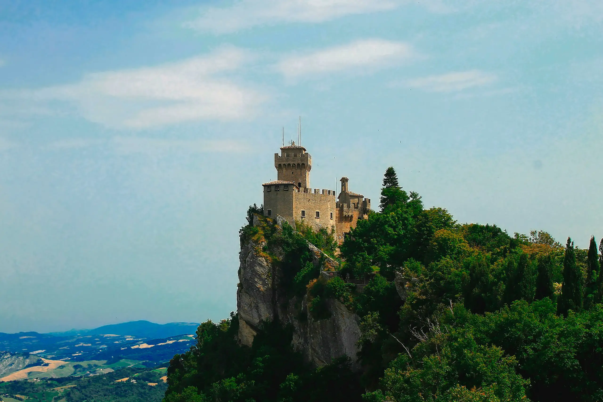 An individual decorates a Christmas tree with various ornaments, creating a joyful holiday atmosphere.