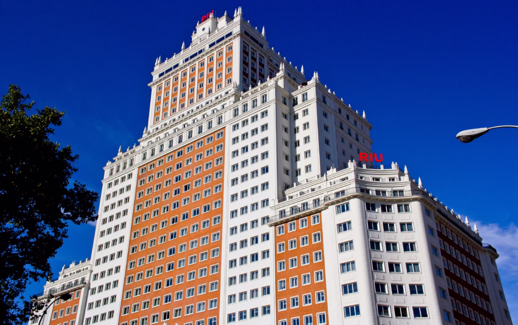 Christmas tree adorned with a sparkling silver star, golden angel, red baubles, and a string of gold beads, evoking a joyful holiday mood.