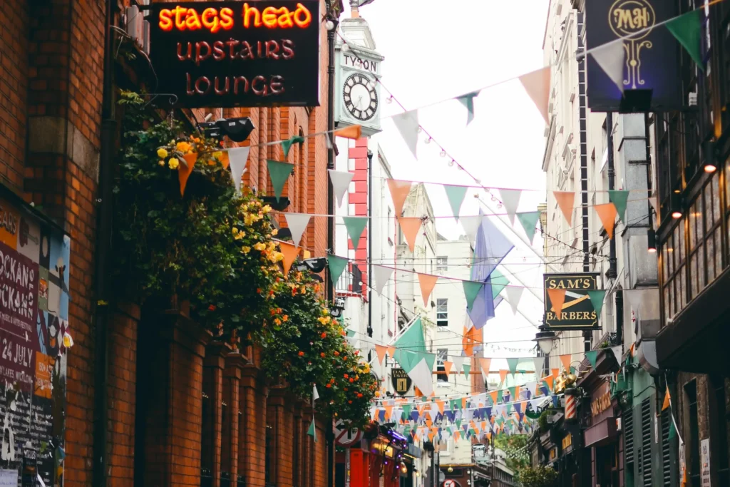 An individual decorates a Christmas tree with various ornaments, creating a joyful holiday atmosphere.