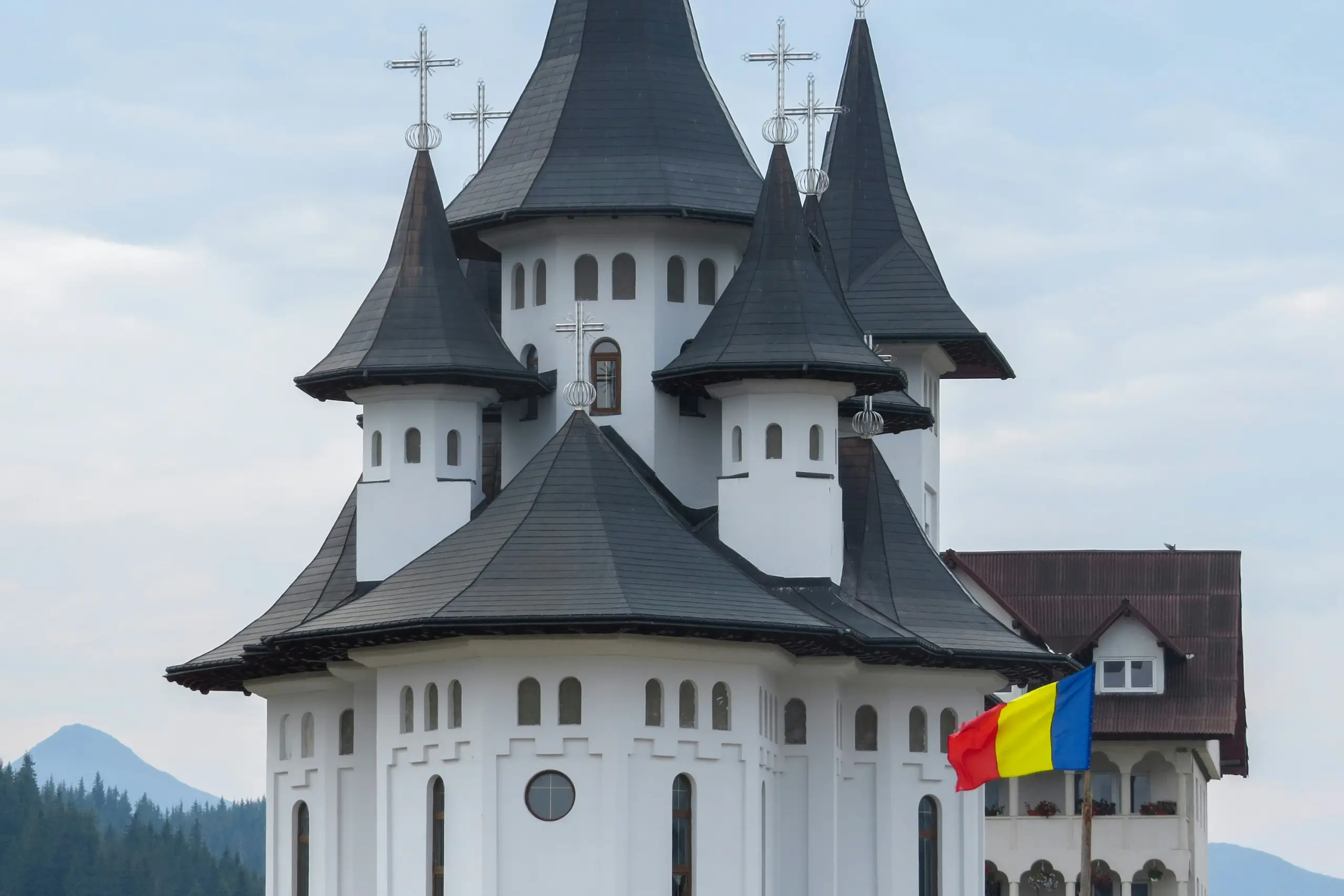 Christmas tree adorned with a sparkling silver star, golden angel, red baubles, and a string of gold beads, evoking a joyful holiday mood.