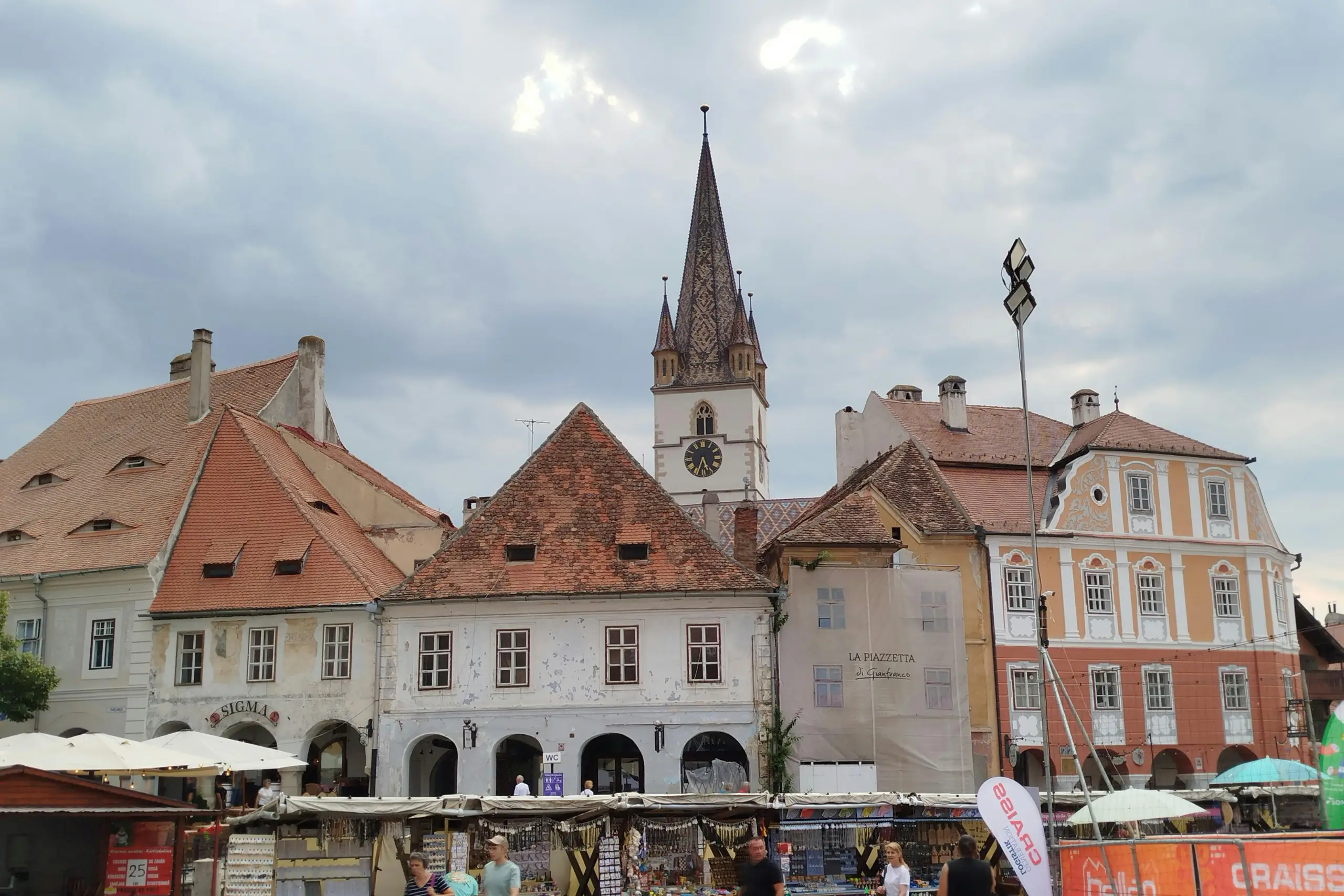 An individual decorates a Christmas tree with various ornaments, creating a joyful holiday atmosphere.